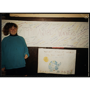 A girl posing in front of a banner bearing the names of the award winners at the 1991 Boys & Girls Club Awards Night