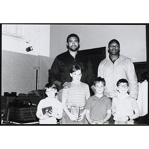 Two former Boston Celtics players, Sly Williams, left, and Sam Vincent, pose for a group picture with four boys holding their awards at a Kiwanis Club's awards ceremony