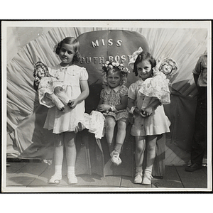 Three winners of the Little Sister Contest pose with their dolls