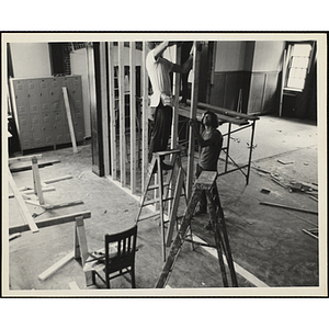 Two men framing an interior wall with wood studs during the Boys' Clubs of Boston Charlestown Clubhouse renovation