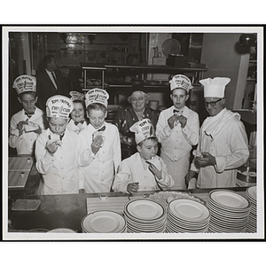 Members of the Tom Pappas Chefs' Club and staff pose with pastries in the Shearton Plaza Hotel testing kitchen