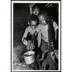 Boys heat a sauce in a brick oven