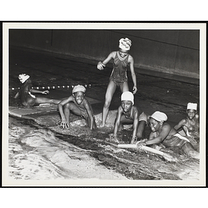 A group of girls occupy a floatation device in a natatorium pool