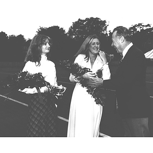 President Ryder presents flowers to two women