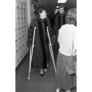 A Law School graduate on crutches at commencement