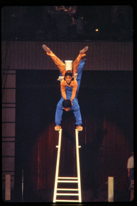 Shanghai acrobats: man and woman balancing act: balancing on ladder with dishes