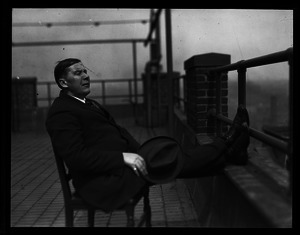 Informal portrait of unidentified man reclining in a chair
