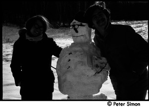 Two unidentified people with snowman at Packer Corners, holding a book of Yeats poetry