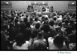 View over the audience of Ram Dass and associates on stage during an appearance at the College of Marin