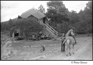 Children and a horse on a dirt path near a dome house, commune members gathered outside, Lama Foundation