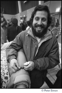 Audience member at the College of Marin after Ram Dass's talk, rolling up a yoga mat