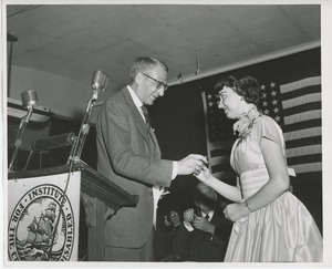 Unidentified man handing gift to client at Institute Day