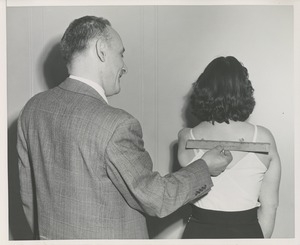 A man measures a patient's back