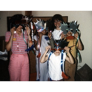 Children in masks posing with an unidentified adult.