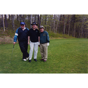A three-man golf team posing on the golf course at the Charlestown Boys & Girls Club Annual Golf Tournament