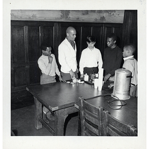 A man and four boys prepare drinks during a Race Committee meeting