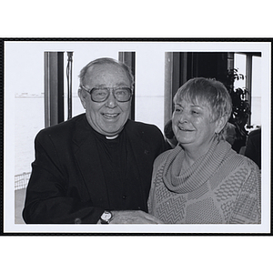 A priest and a woman standing together at a St. Patrick's Day Luncheon