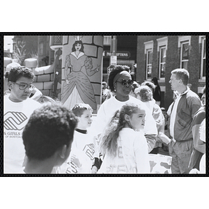 Several Club members wearing Boys and Girls Clubs of Boston t-shirts stand together near an inflatable "Kiddie Kastle" at the Boys and Girls Clubs of Boston 100th Anniversary Celebration Street Fair