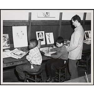 An art instructor and two boys working on drawings at the Boys' Clubs of Boston