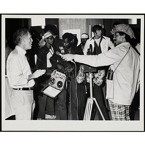 Mayor of Boston Kevin H. White (far left) is interviewed by a young man holding a microphone