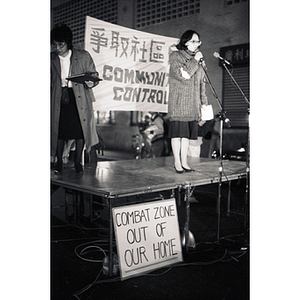 As the previous speaker steps off the stage, an Asian woman talks into a microphone at an evening demonstration to take back the Chinatown community from the encroaching Combat Zone, the infamous red-light district in Boston