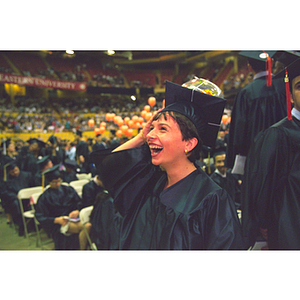 Student at commencement with globe beach ball tied to the mortarboard of her academic cap