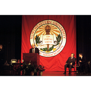 Dean Robert Lowdnes stands at a podium at the inauguration of the International Degree Program