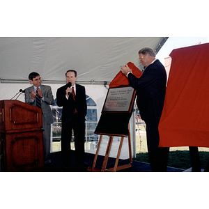 Robert Shillman speaks into a microphone after the plaque for Shillman Hall is unveiled at its dedication