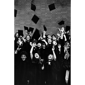 School of Law graduates toss their hats in the air after commencement