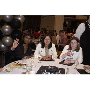 Three young women sitting at a table together during the Student Activities Banquet