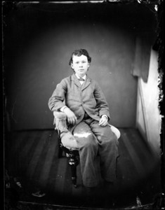 Full portrait of a boy, seated in a chair