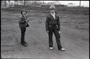 Two boys standing in a muddy lot