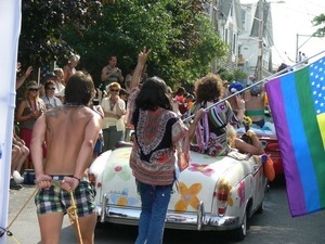 Parade marchers carrying an American flag made like a pride flag : Provincetown Carnival parade