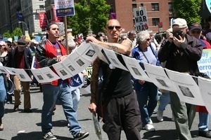 Marchers carrying a long string of photos of soldiers killed in Iraq, during the protest against the war in Iraq