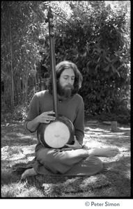 Krisha Das: portrait of the vocalist with Amazing Grace and member of the Ram Dass satsang, seated in a lotus position with an dotara