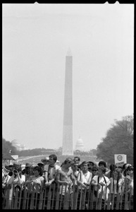 Crowd lined up along a fence, watching the 25th Anniversary of the March on Washington