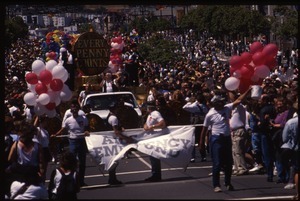 AIDS Emergency Fund marching in the San Francisco Pride Parade with float large in the rear: 'Every Penny Counts'