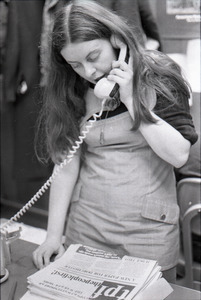 Bernadette Devlin McAliskey on the phone at the WBCN office with copy of the 'the people first'