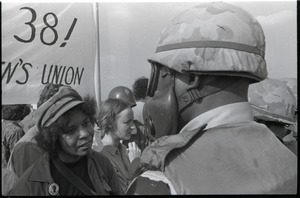 Antiwar demonstration at Fort Dix, N.J.: protester speaking with military policeman in gas mask