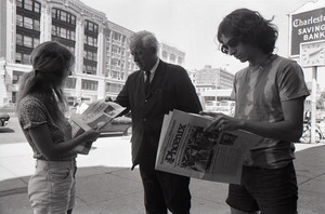 Boston Phoenix promotional photos: Phoenix hawker handing paper to man, Stephen Davis (r) reading