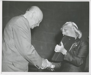 Margaret Milbank Bogert holds the 1956 President's Trophy and shakes Dwight D. Eisenhower's hand