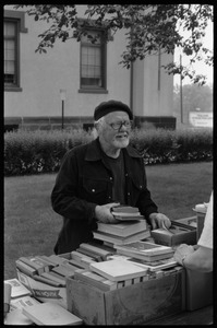Thomas C. Crowe looking over books at a tag sale at the Unitarian Society, Northampton (town hall in background)