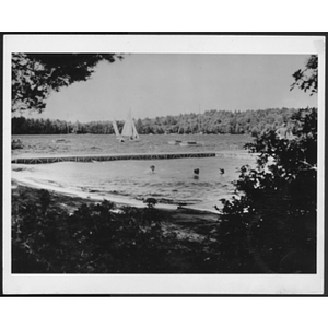 View of lake with swimmers and sailboat at unidentified YMCA camp