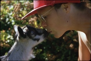 Sandi and baby goat kiss
