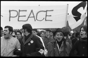 Lead contingent of the march at the Counter-inaugural demonstrations, 1969, chanting beneath a sign reading 'Peace'