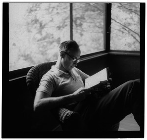 Sidney Lipshires seated on a porch, reading