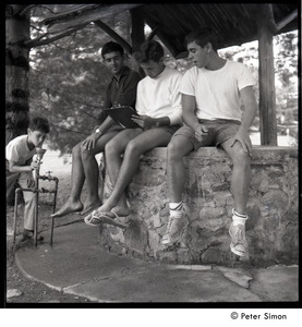 Camp Arcadia: three campers seated on a well