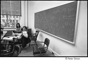 MIT war research demonstration: man and woman sitting in a classroom