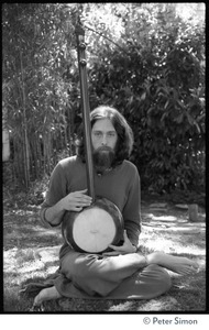 Krisha Das: portrait of the vocalist with Amazing Grace and member of the Ram Dass satsang, seated in a lotus position with an dotara