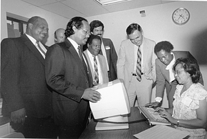 Mayor Raymond L. Flynn, City Councilor Charles Yancey and others watching a woman work on a word processor